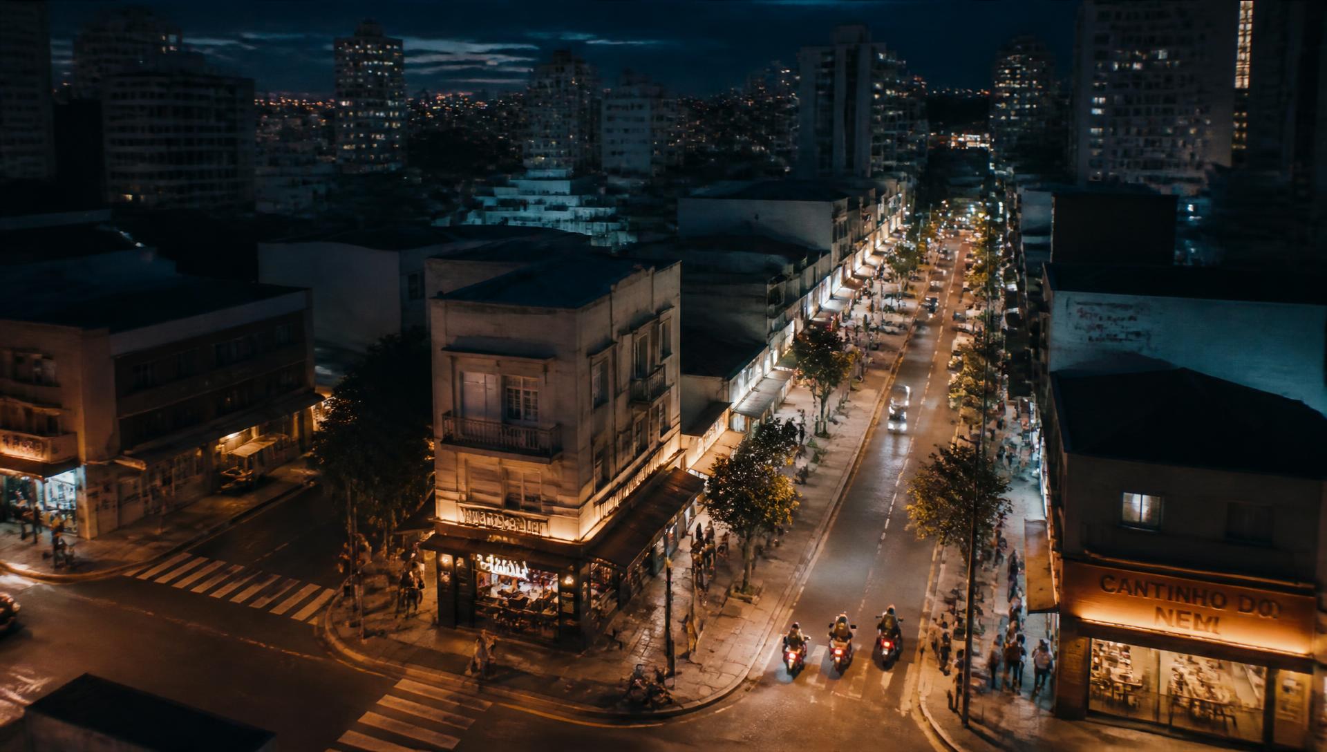 Rua de uma cidade brasileira com lojas e pessoas ao anoitecer